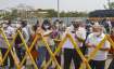 People stand behind a barrier outside a Covid-19