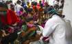 A health worker administers a dose of Covaxin as hundreds