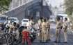 Police personnel stop migrants on their way back to reach