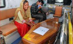 Family members mourn near a casket containing remains of