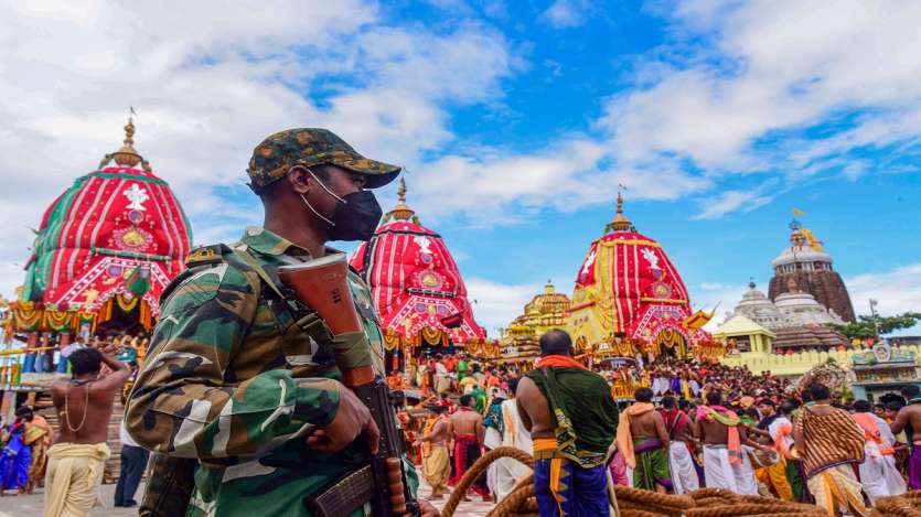 A police person stands guard during the annual Rath Yatra festival in Puri.