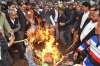 People burn a Pakistani flag during a protest against the